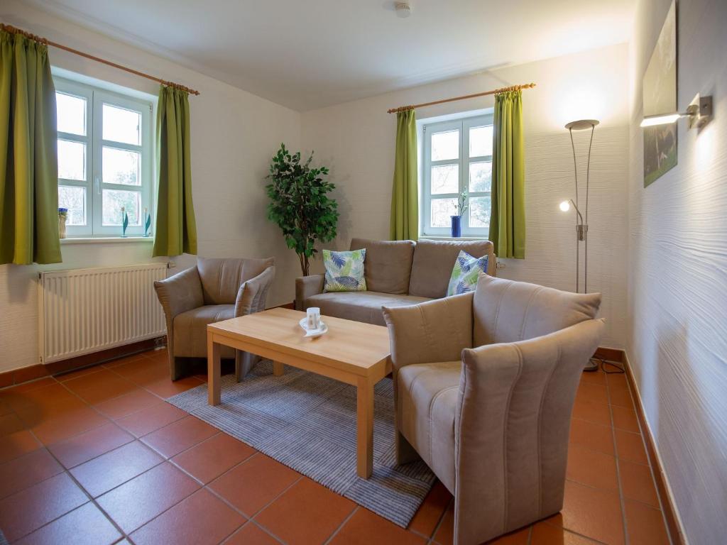 een woonkamer met een bank, stoelen en een tafel bij Feriendorf Rugana - Komfort Appartement mit 1 Schlafzimmer und Terrasse B52 in Dranske