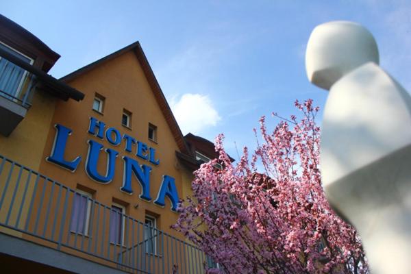 a hotel luna with pink flowers in front of a building at Hotel Luna Budapest in Budapest