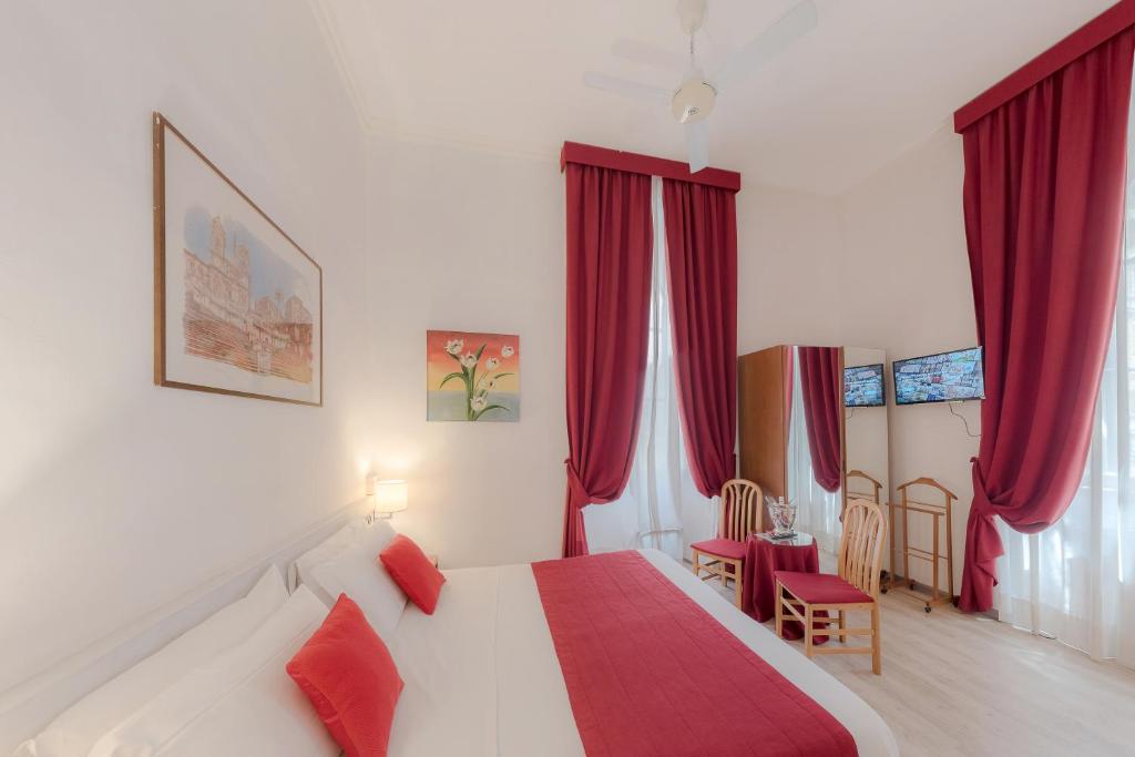 a bedroom with a large bed with red curtains at Hotel Giotto Flavia in Rome