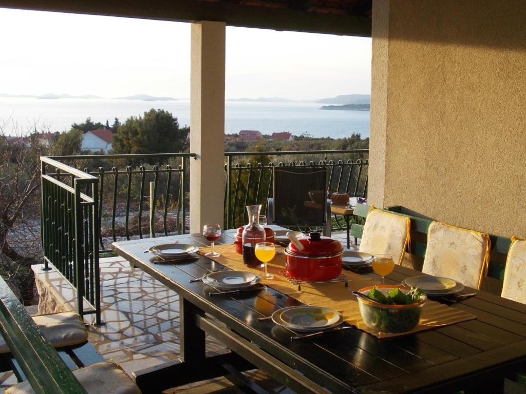 a table on a balcony with a view of the ocean at Holiday Home Primosten (54) in Primošten