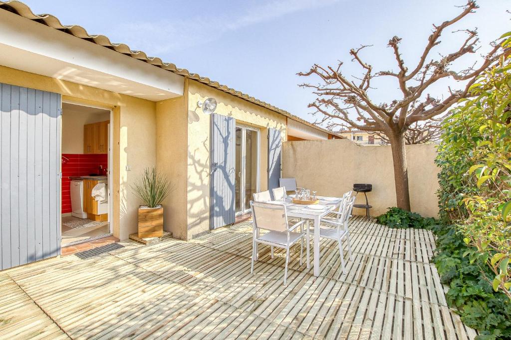 une terrasse avec une table et des chaises. dans l'établissement Primavéra, à Sanary-sur-Mer