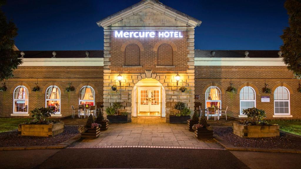 un grand bâtiment en briques avec un panneau indiquant un hôtel négatif dans l'établissement Mercure Haydock Hotel, à Haydock