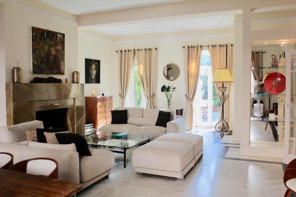 uma sala de estar com mobiliário branco e uma lareira em Garden Mansion in Historic Centre 4 by Lisbonne Collection em Lisboa