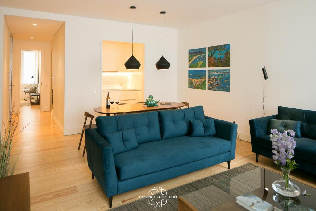 ein Wohnzimmer mit einem blauen Sofa und einem Tisch in der Unterkunft Downtown Stylish by the River 66 by Lisbonne Collection in Lissabon