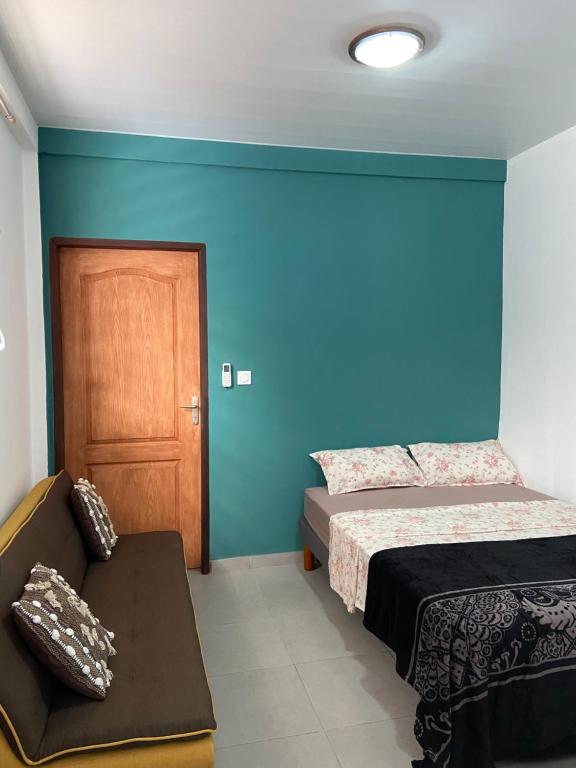 a bedroom with two beds and a chair and a door at Kayenn’Apparts in Cayenne