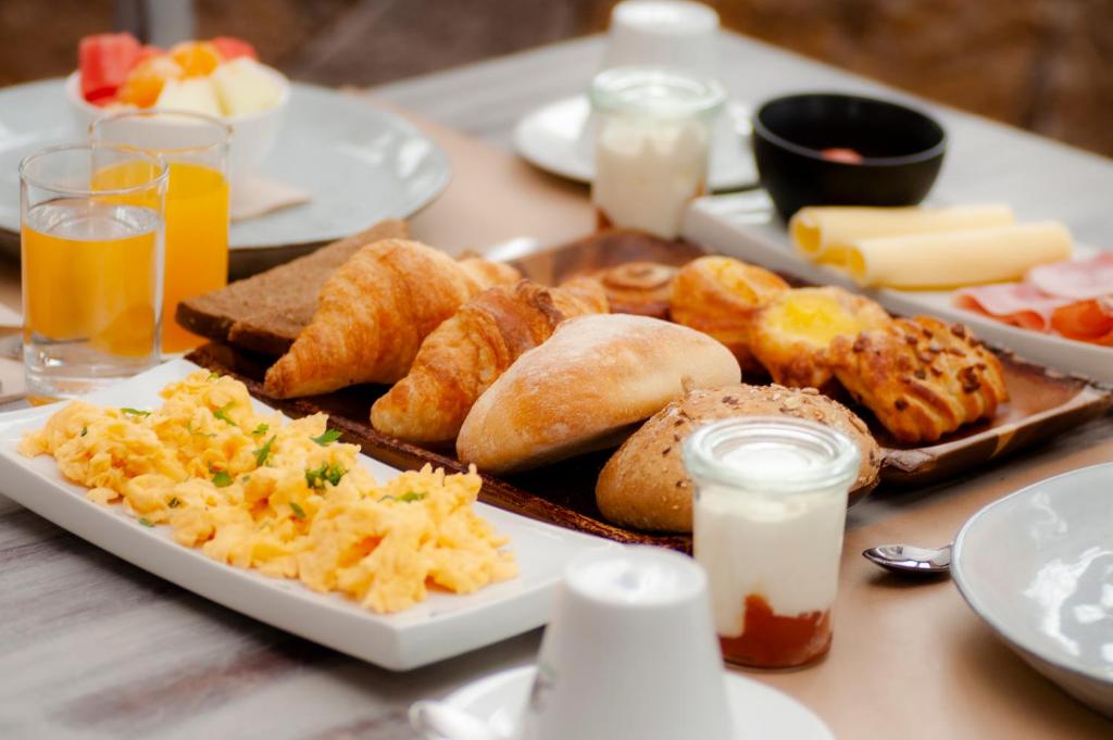 una mesa cubierta con platos de comida y bebida para el desayuno en Hotel El Tejar & Spa, en Vilaflor