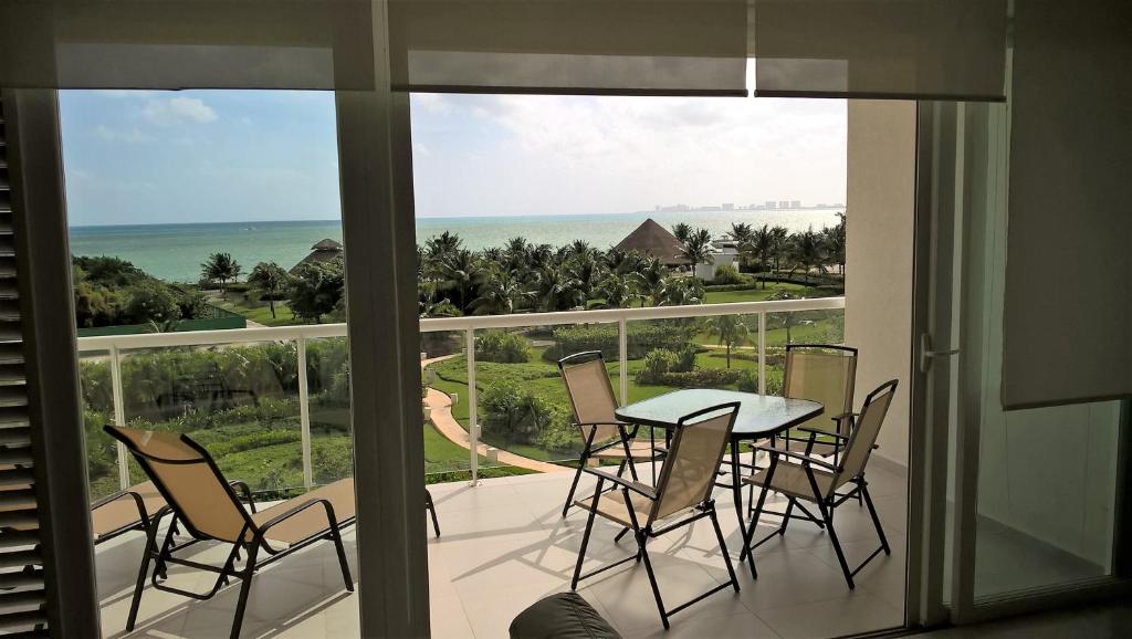 uma varanda com mesa e cadeiras e vista para o oceano em Swim the Caribbean & Work with a View em Cancún