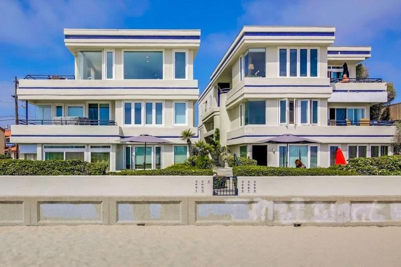 a large white house on the beach next to the sand at 125-fun In The Sun Penthouse in San Diego