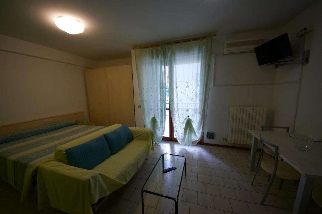 Habitación con cama, sofá y ventana en Residence Parmigianino en Parma