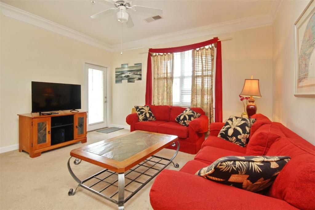 un soggiorno con mobili rossi e TV a schermo piatto di 2302 Crow Creek Drive a Calabash