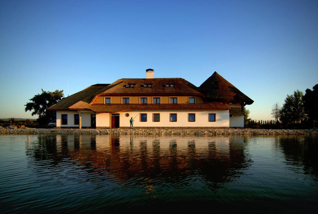 a house sitting on the shore of a body of water at Penzión Eko Park Piešťany in Piešťany