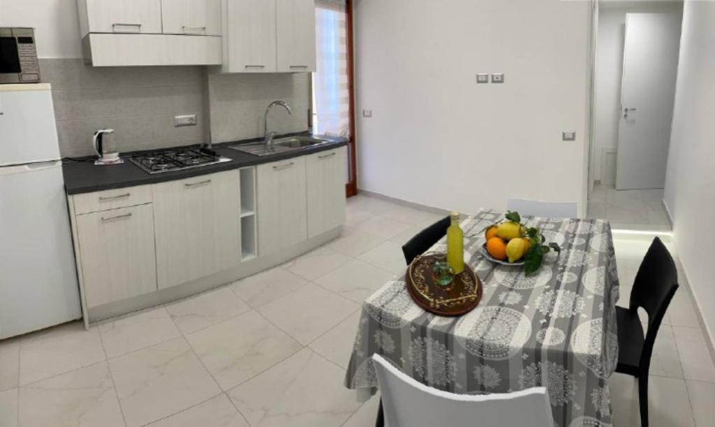 a kitchen with a table with a bowl of fruit on it at A Casa e' Mammà in Sorrento