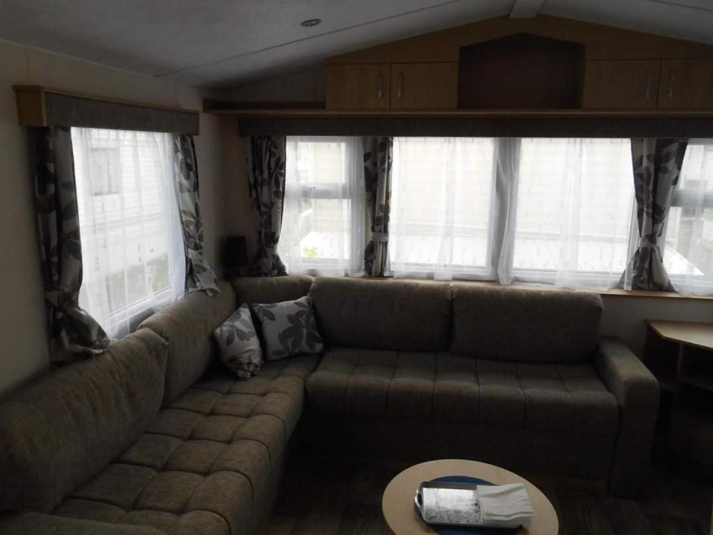 a living room with a couch and a table at Luxe vakantiechalet met omheinde tuin Bredene 6pers (2572) in Bredene