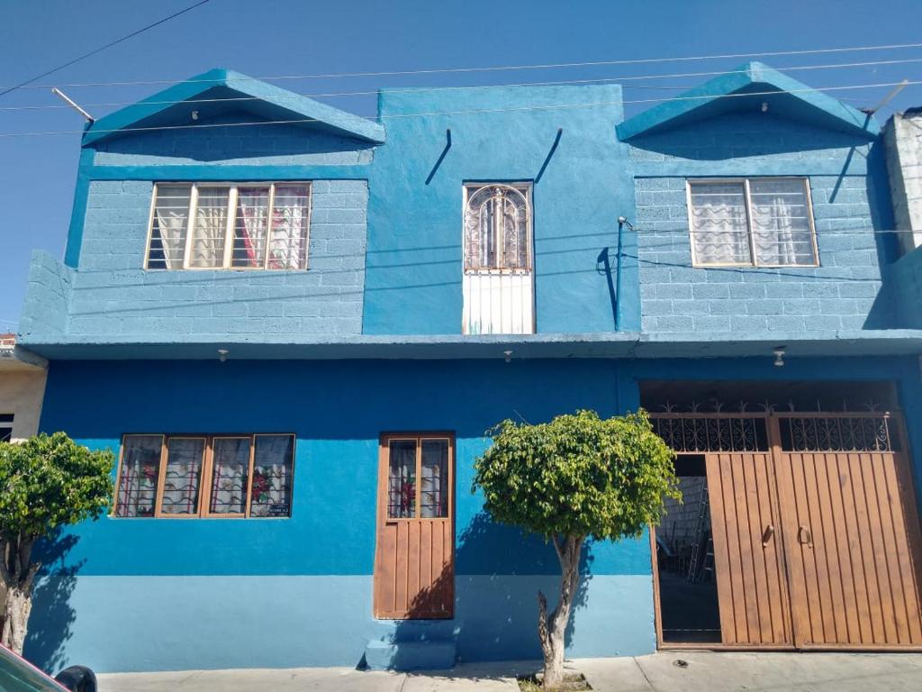 Aquetzali Kin Casa Privada con alberca في كواوتلا موريلوس: منزل أزرق مع نوافذ مقلوبة