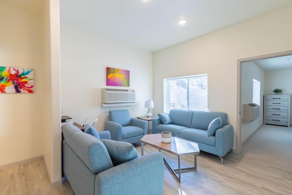 uma sala de estar com dois sofás azuis e uma mesa em The Molina Center em Mesa