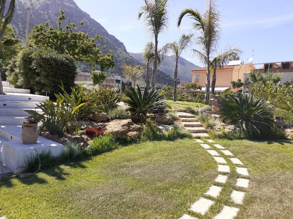 カステッランマーレ・デル・ゴルフォにあるCasa con giardinoの椰子の木と石道のある庭園