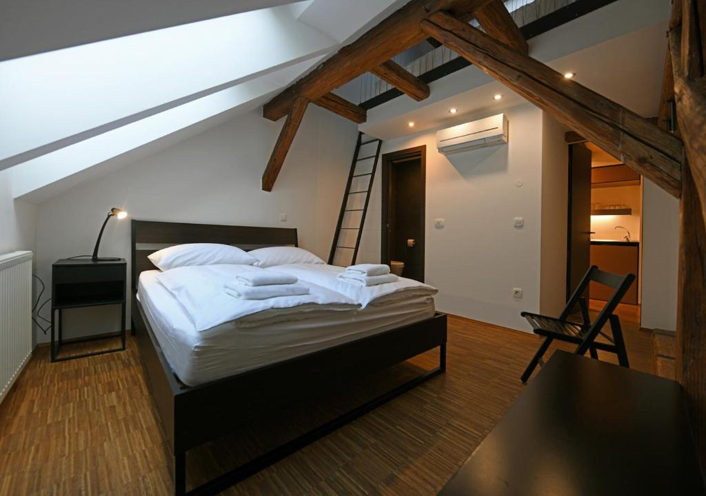 a bedroom with a bed with a ladder and a table at ATIK ROOMS in Ljubljana