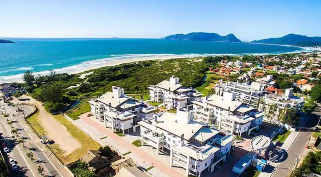 an aerial view of a beach with white houses at Apartamento na Praia do Campeche in Florianópolis