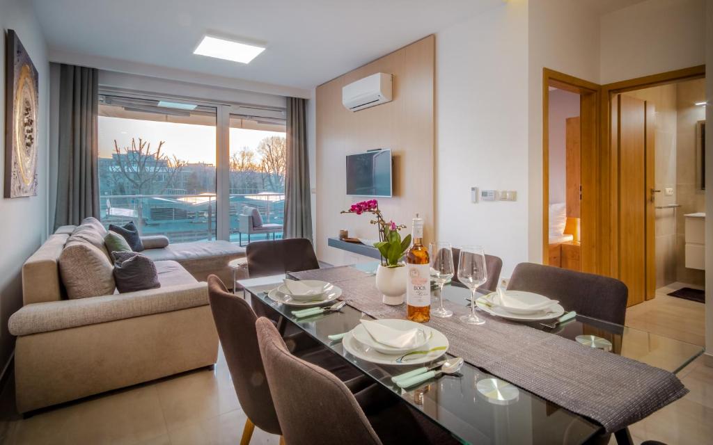 een eetkamer en een woonkamer met een tafel en stoelen bij MF Casa Panorama Apartment in Siófok