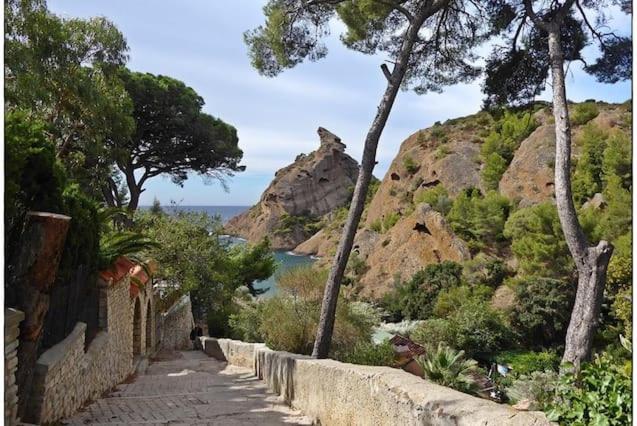 un camino de piedra con árboles y vistas al océano en La Campagne, en La Ciotat