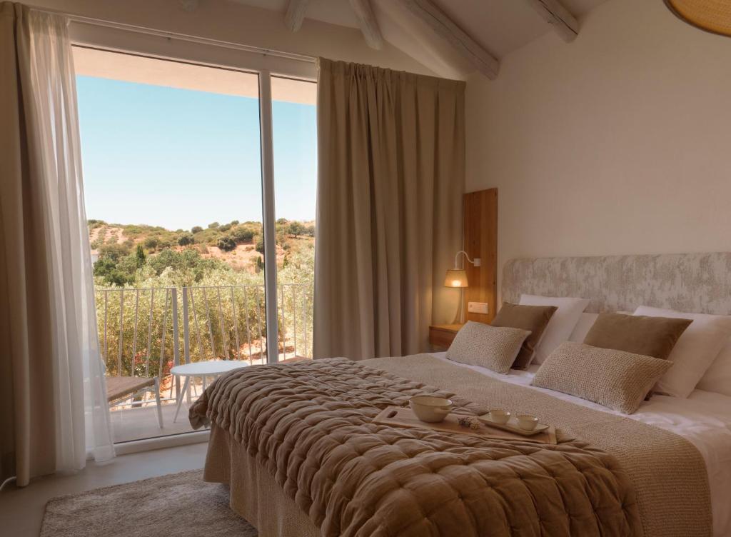 Un dormitorio con una cama grande con una ventana grande. en Hacienda Fresneda María by Charming Stay Adults Recommended, en Villanueva del Rosario