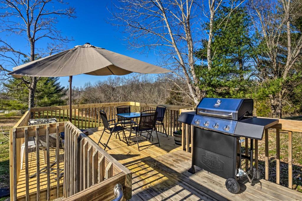 una parrilla en una terraza con mesa y sombrilla en Boating Mecca Near Dale Hollow Lake and Golf!, en Frogue