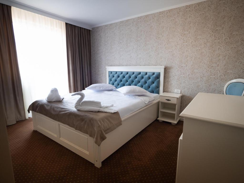 een slaapkamer met een wit bed en een raam bij Pensiunea RYN in Sebeş