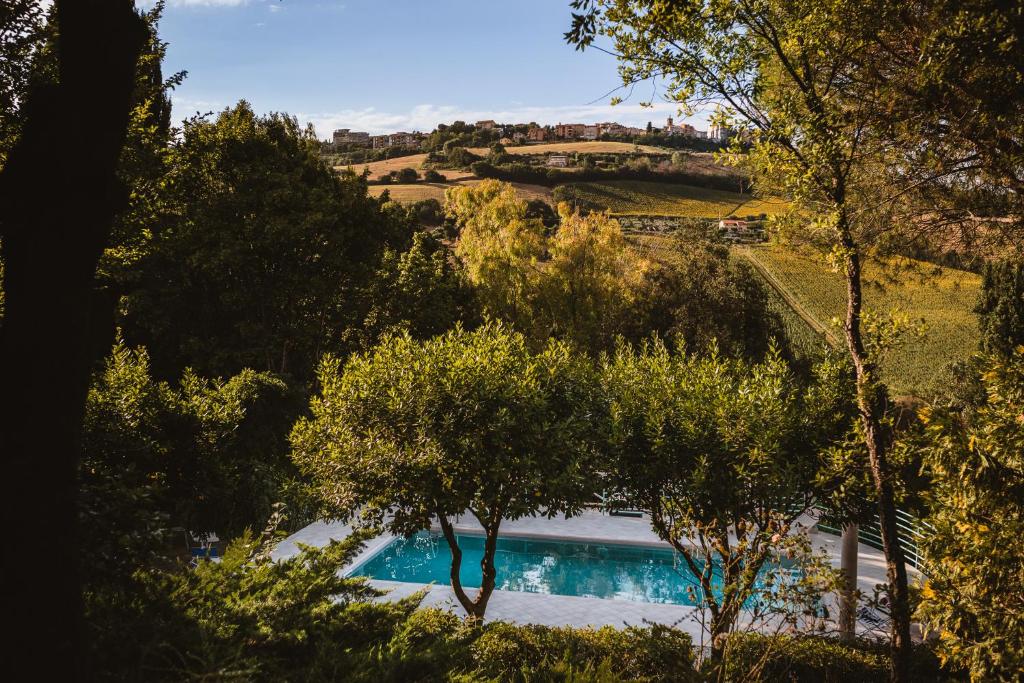 une piscine au milieu d'une colline arborée dans l'établissement Italian Experience-Villa Millefiori, à Porto San Giorgio