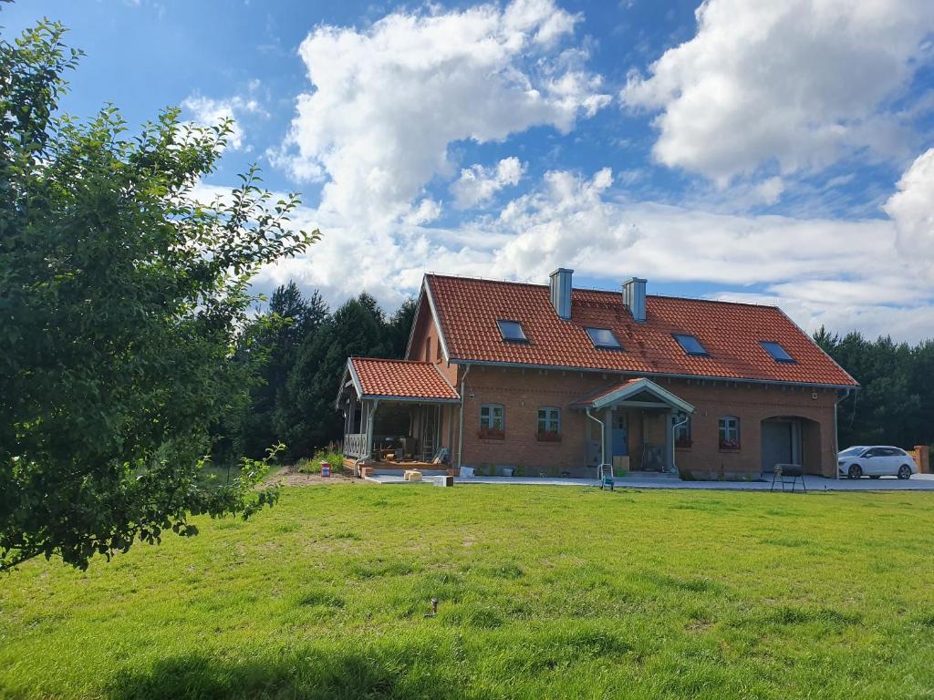 una grande casa con un prato davanti di Przyjaciół Dom Nad Jeziorem - Mazury a Miłuki
