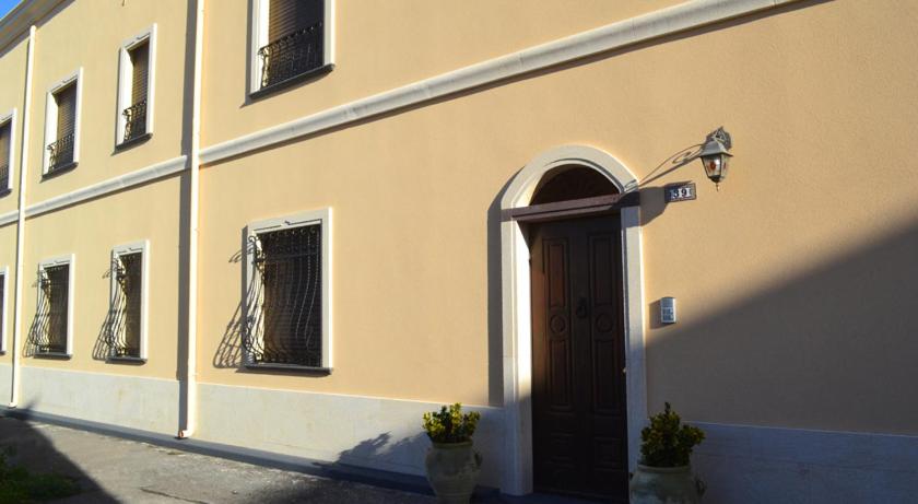 a building with a brown door and a window at Appartamenti famiglia Pinna - Sa Domu Antiga - in Càbras