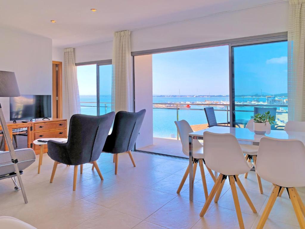a dining room with a table and chairs with a view at Cofradia Penthouse in Alcudia