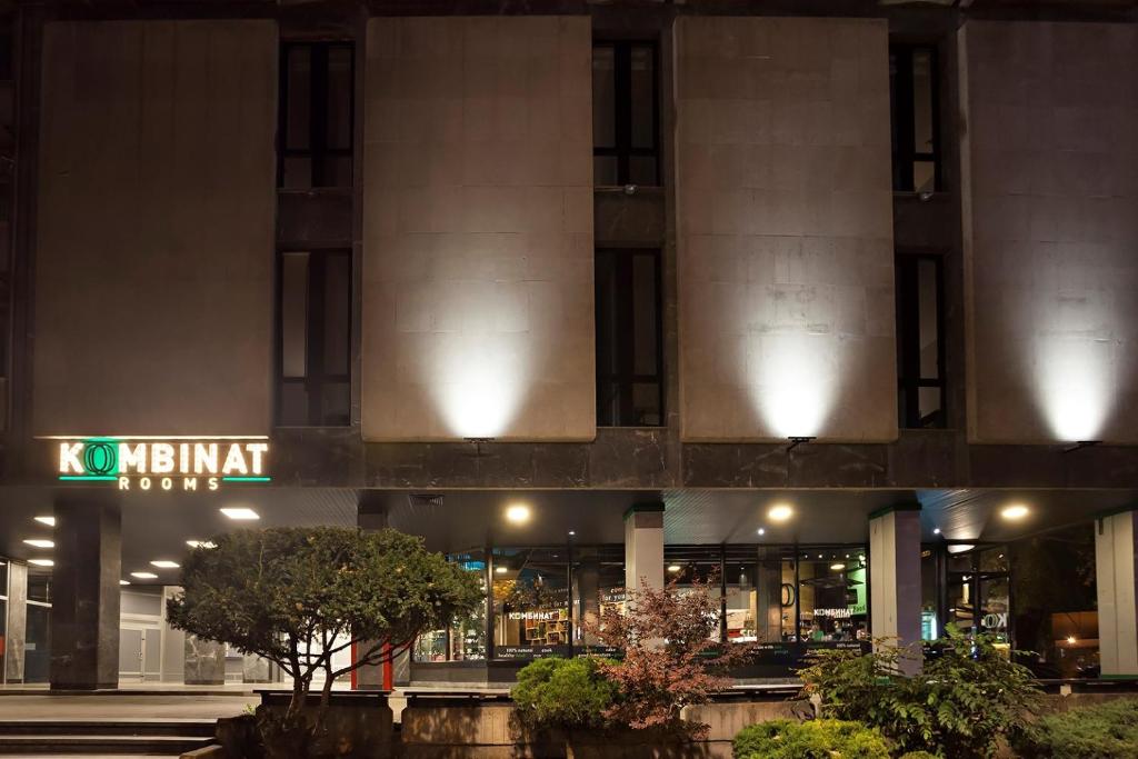 a building with a sign in front of it at night at Kombinat Rooms City Center in Novi Sad