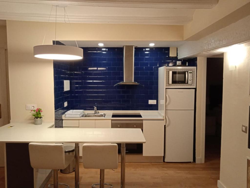 a kitchen with a white refrigerator and a table with chairs at APARTAMENTOS En Plom in Valencia
