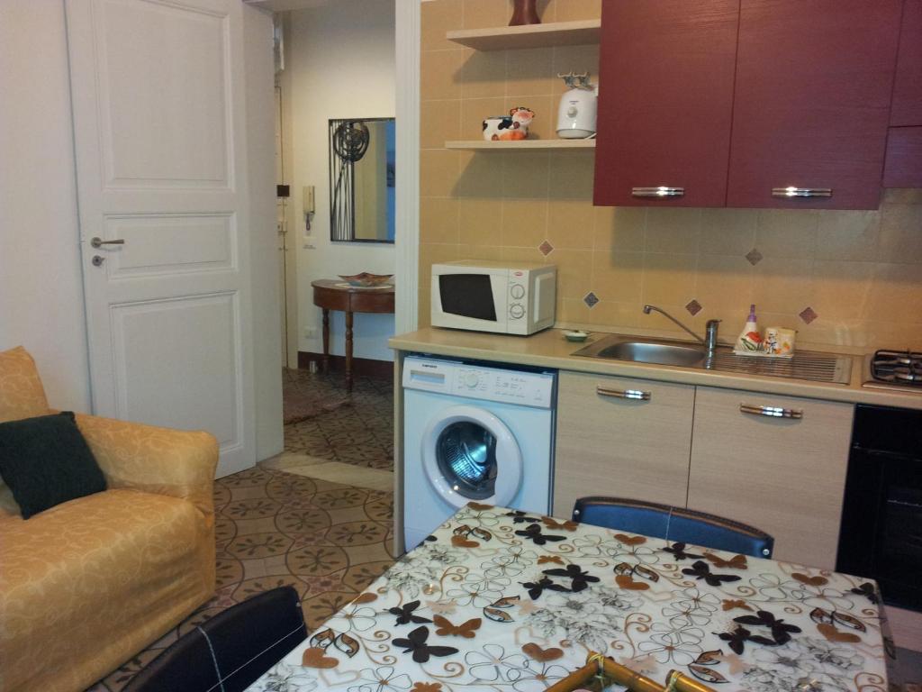 a kitchen with a washing machine and a microwave at Casa Vacanze Trapani Via Mercè in Trapani