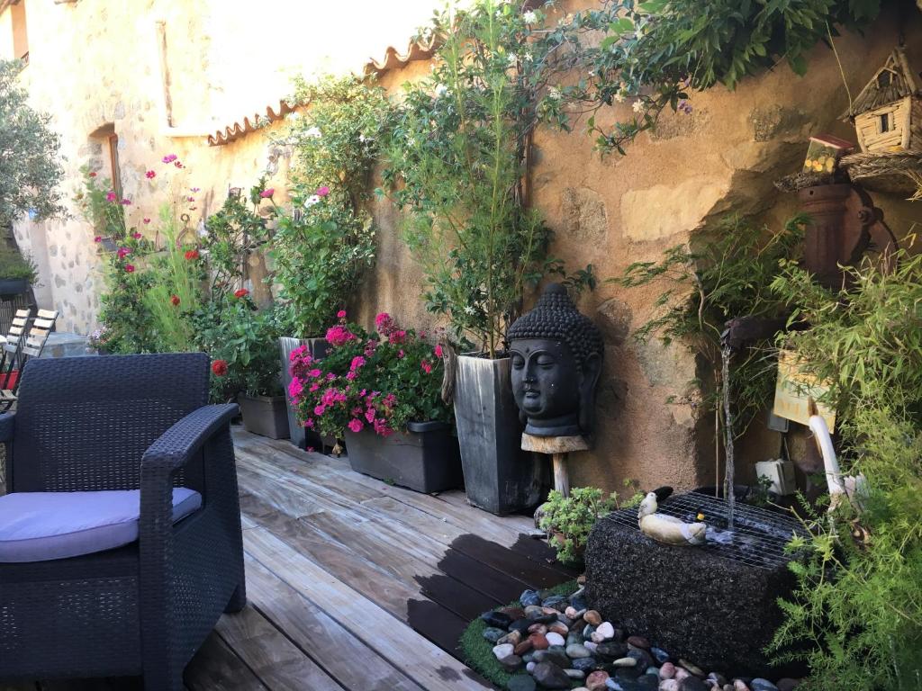 a patio with a garden with a statue and flowers at Chez Marco Gîte & SPA CAPPELLINA in Muro