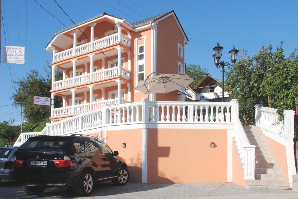 a car parked in front of a building with an umbrella at Villa Ana in Gornja Trepča