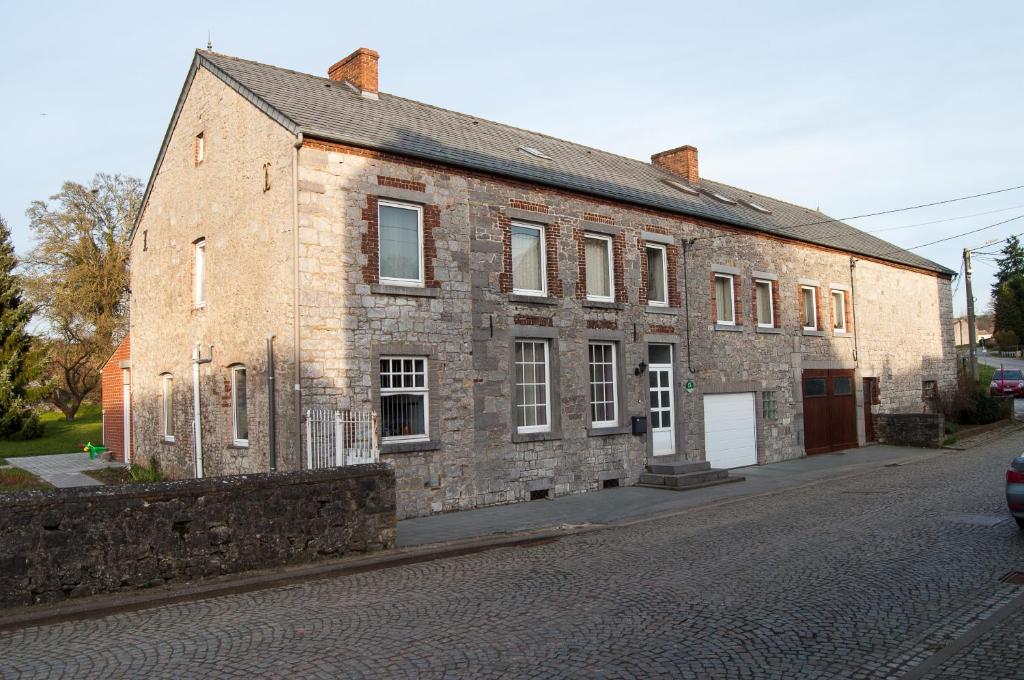 un vieux bâtiment en briques situé sur le côté d'une rue dans l'établissement Chambres d'hôtes de la Quairelle, à Gerpinnes