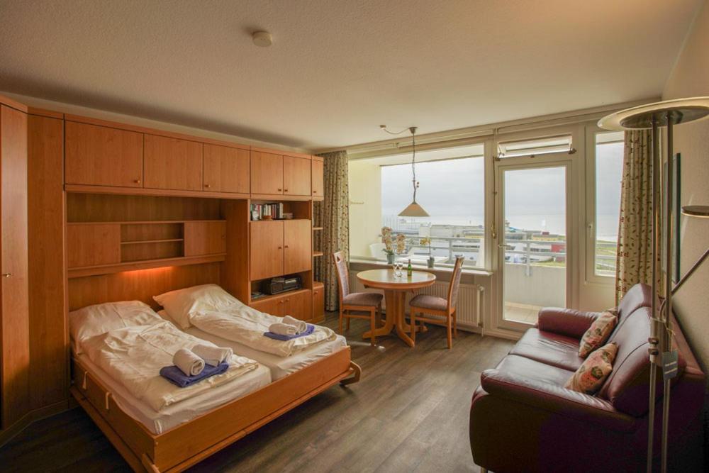 - une chambre avec un lit, un canapé et une table dans l'établissement Strandliebe Borkum, à Borkum