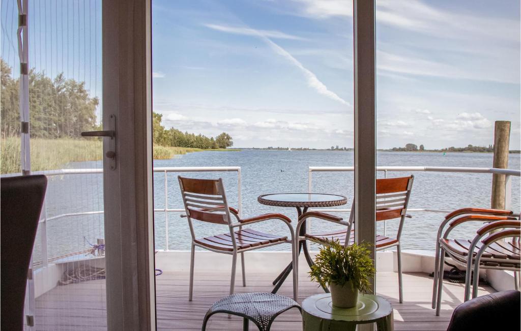 a porch with chairs and a table and a view of the water at Gorgeous Ship In Biddinghuizen With Wifi in Biddinghuizen