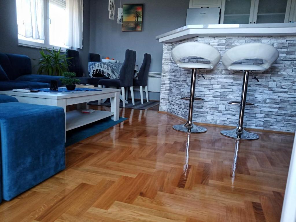 a living room with two stools in front of a fireplace at Apartman Sunset Trebinje in Trebinje