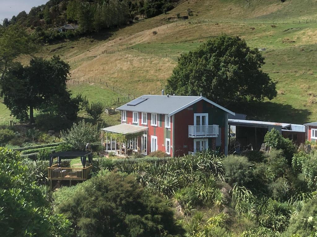 a red house in a field with a hill at The Pear Orchard Lodge in Richmond