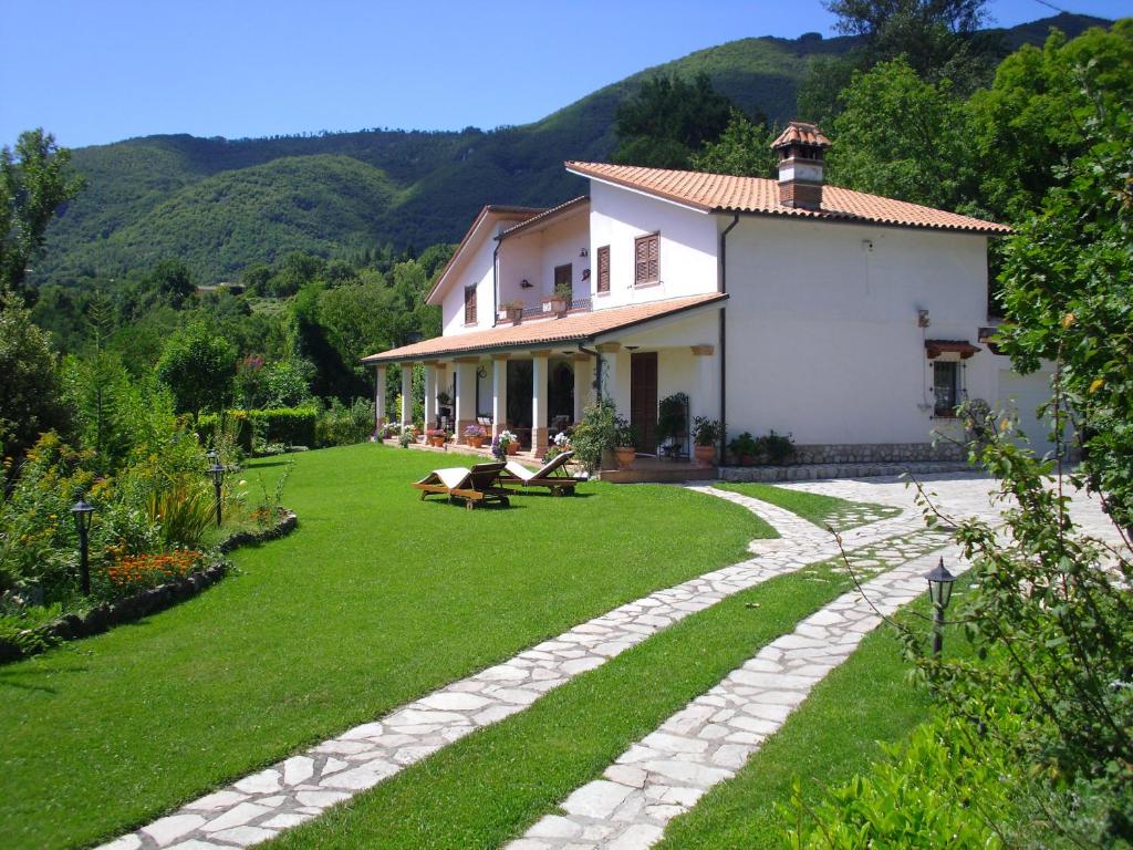 uma casa com um jardim relvado ao lado de um edifício em B&B Il Cantico em Greccio