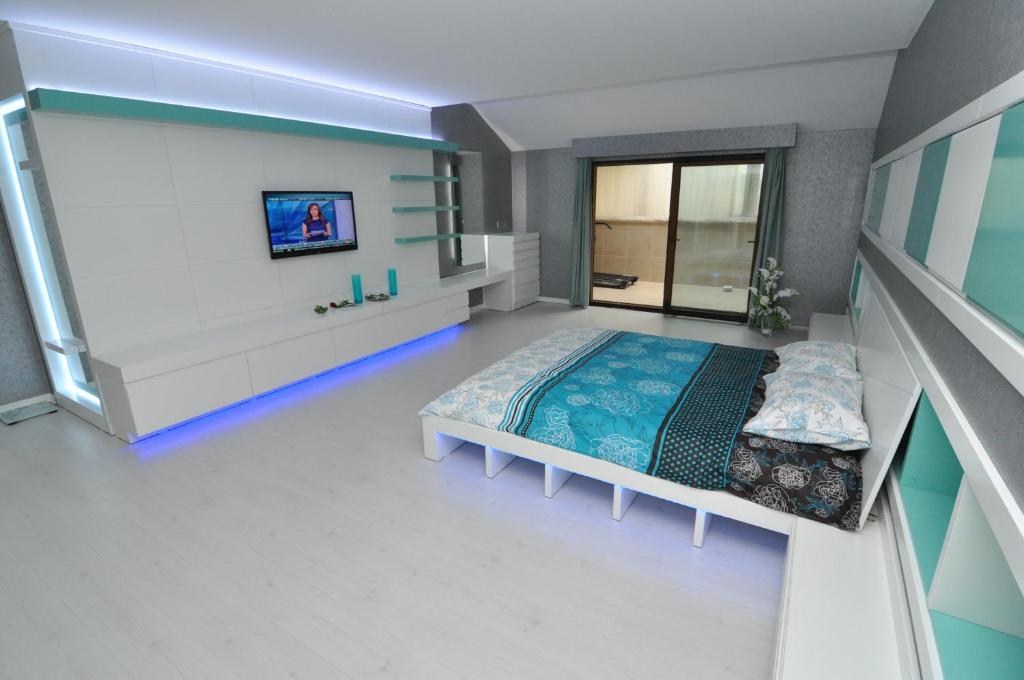 a bedroom with a bed and a tv on a wall at Dekar Apartments in Trabzon