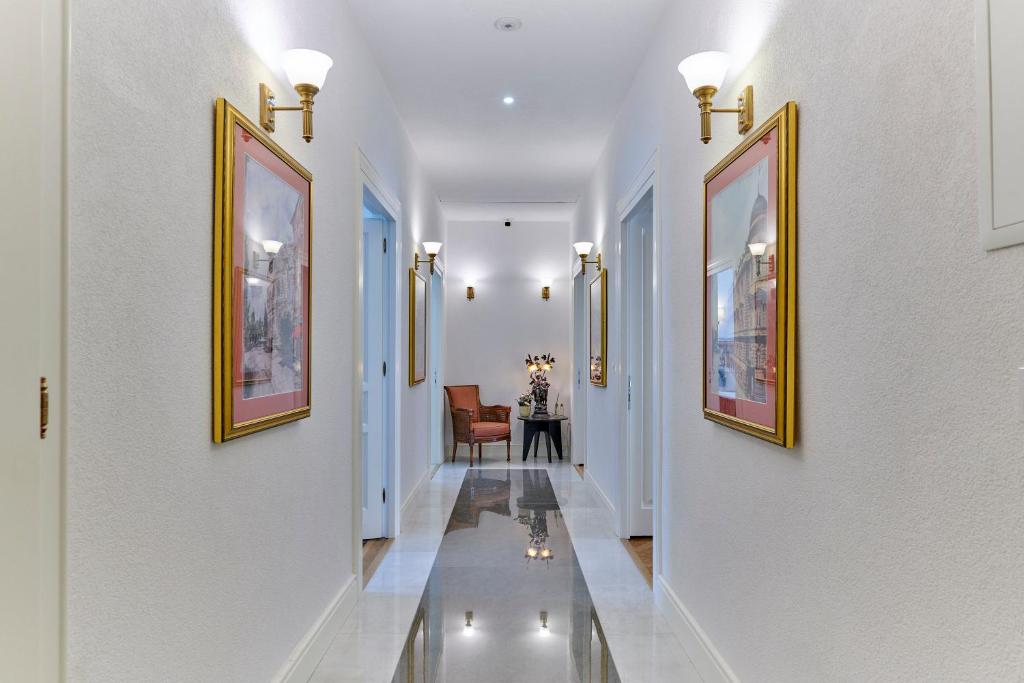 un corridoio con pareti bianche e dipinti alle pareti di Casa Dei Fiori a Pola (Pula)