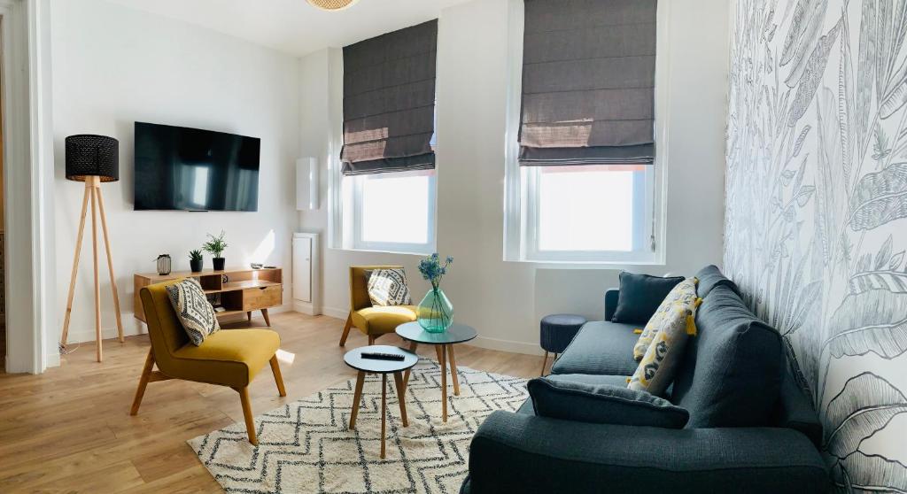 a living room with a blue couch and yellow chairs at Villa Haze in Tourcoing