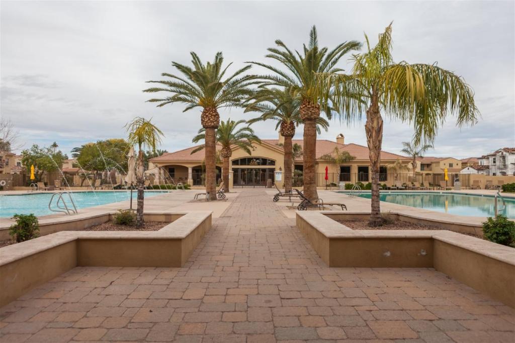a resort with palm trees and a swimming pool at Gated townhouse with heated pool, hot tub, near US60 in Mesa