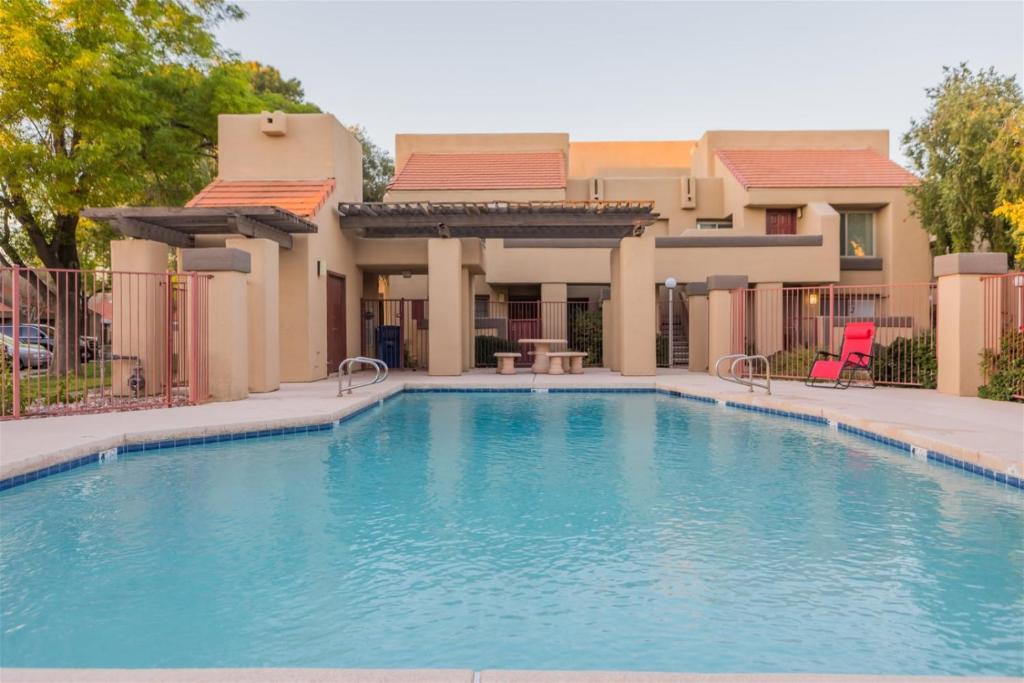 una piscina di fronte a una casa di Cozy condo near MCC with pool, BBQ, covered parking a Mesa