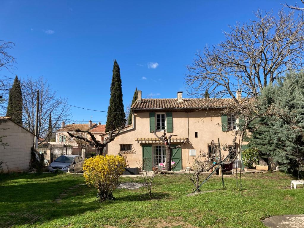 une grande maison en pierre avec une porte verte dans l'établissement LE MAS, à Aix-en-Provence