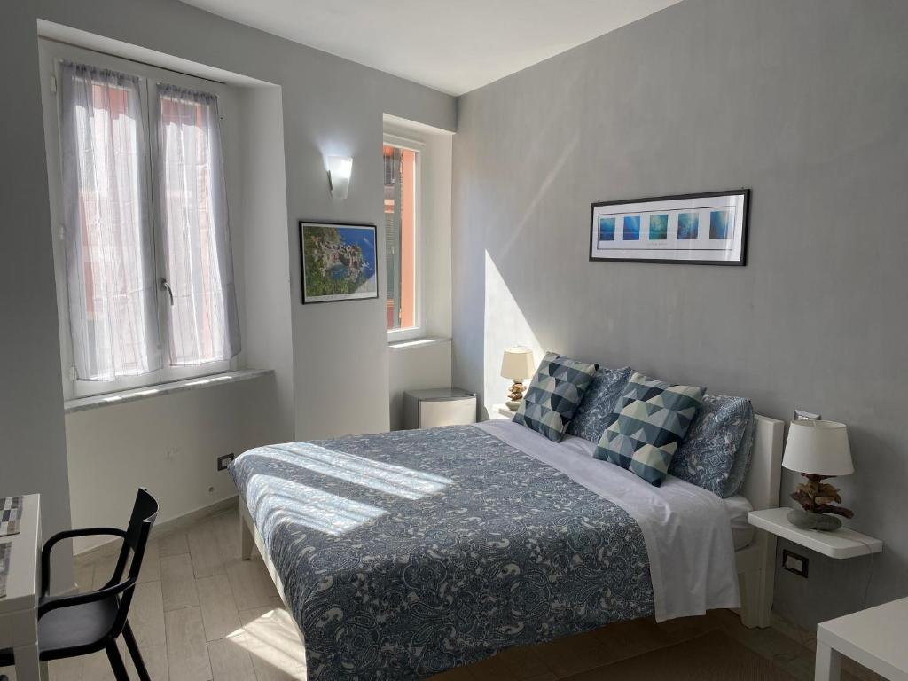 a bedroom with a bed and a chair and windows at SeaBreeze Vernazza in Vernazza