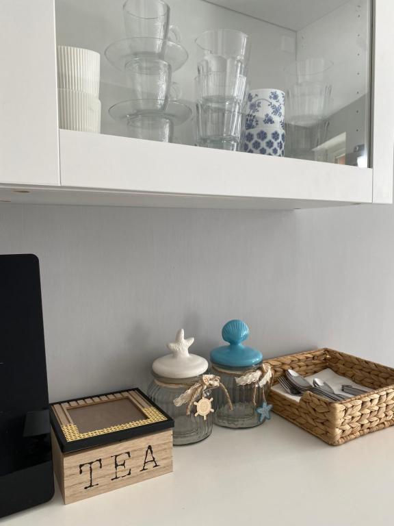 a shelf with dishes and a tea box on a counter at SeaBreeze Vernazza in Vernazza